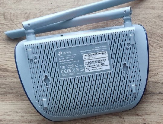 قسمت زیرین مودم tp-link td-w9960 با برچسب مشخصات دستگاه و دو حفره برای نصب دیواری